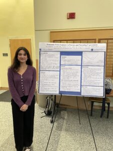 A student, Anvi Kesarwani, standing in front of her research poster