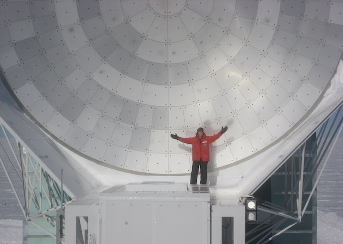 small figure in front of a parabolic dish