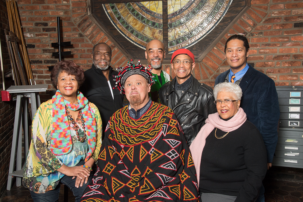 Seven alumni artists pose for the camera